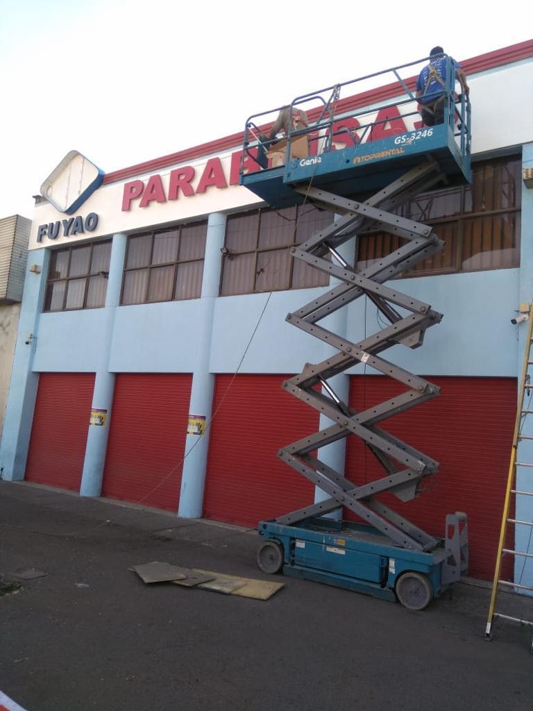 Instalación de letrero publicitario en altura con plataforma elevadora tijera